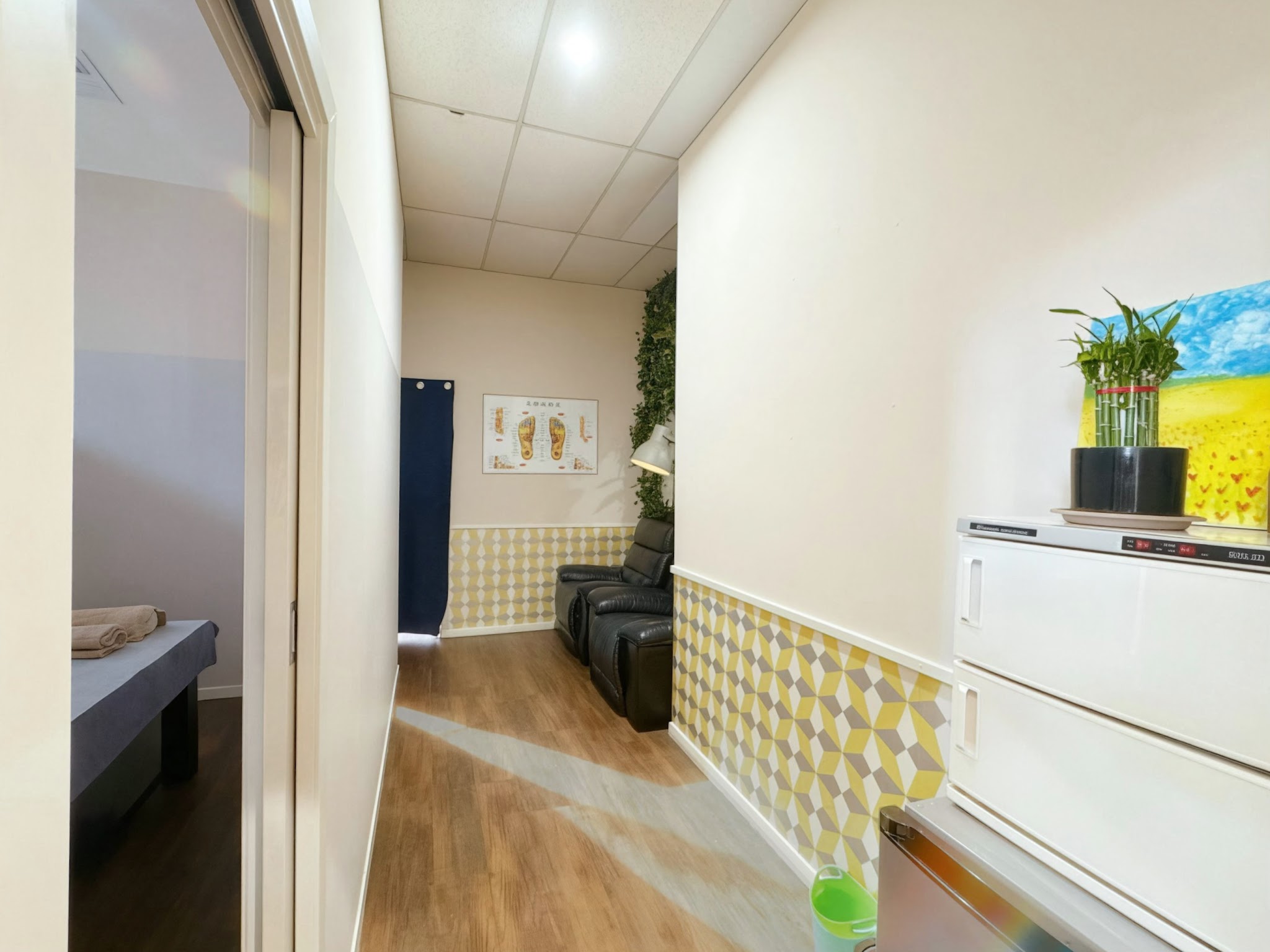 Hallway with a foot reflexology chart on the wall and the foot lounge at the end